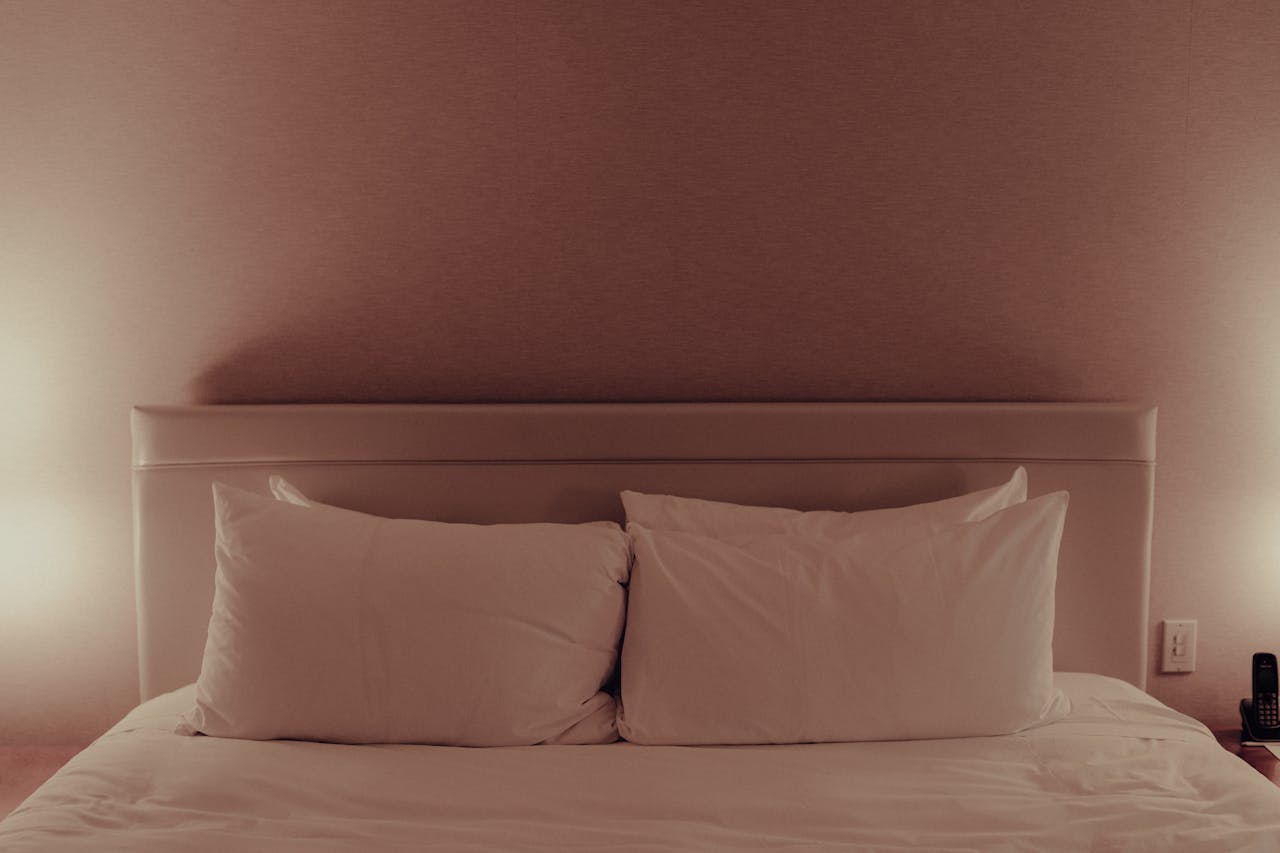 A bed with pillows and lamps on it